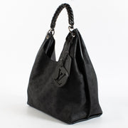 Louis Vuitton Carmel Hobo in black Mahina perforated calf leather with braided handle, silver-tone hardware and roomy interior. Shop now at Labellov.com