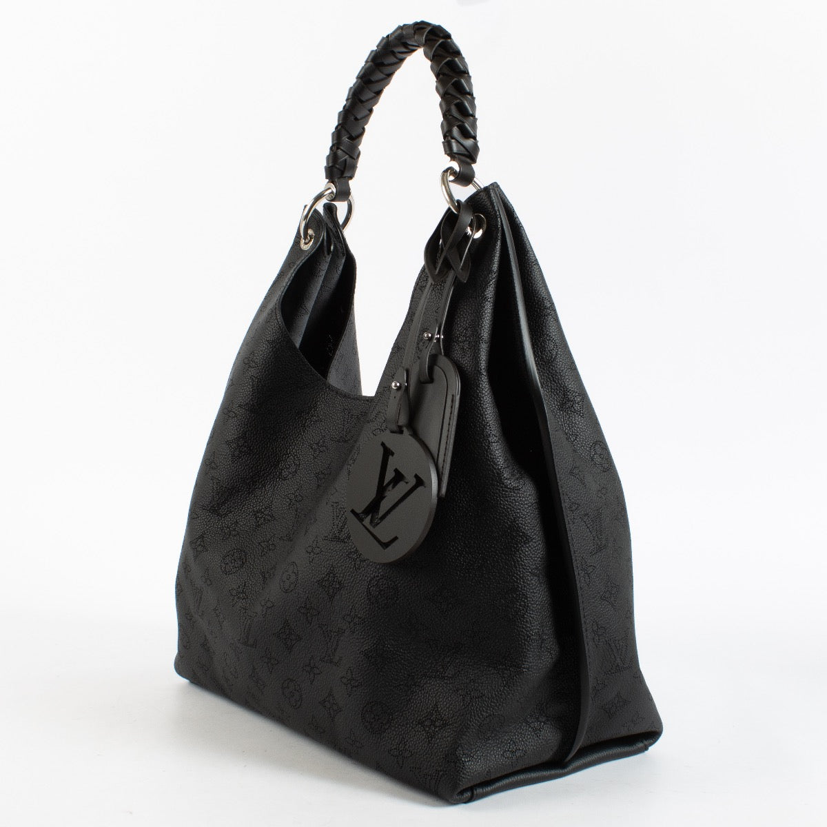 Louis Vuitton Carmel Hobo in black Mahina perforated calf leather with braided handle, silver-tone hardware and roomy interior. Shop now at Labellov.com