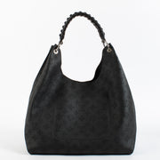 Louis Vuitton Carmel Hobo in black Mahina perforated calf leather with braided handle, silver-tone hardware and roomy interior. Shop now at Labellov.com