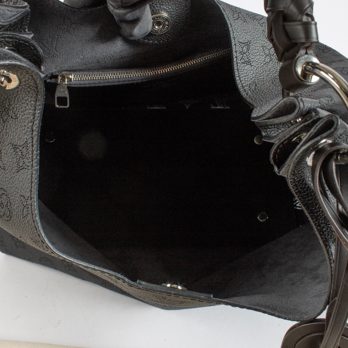 Louis Vuitton Carmel Hobo in black Mahina perforated calf leather with braided handle, silver-tone hardware and roomy interior. Shop now at Labellov.com