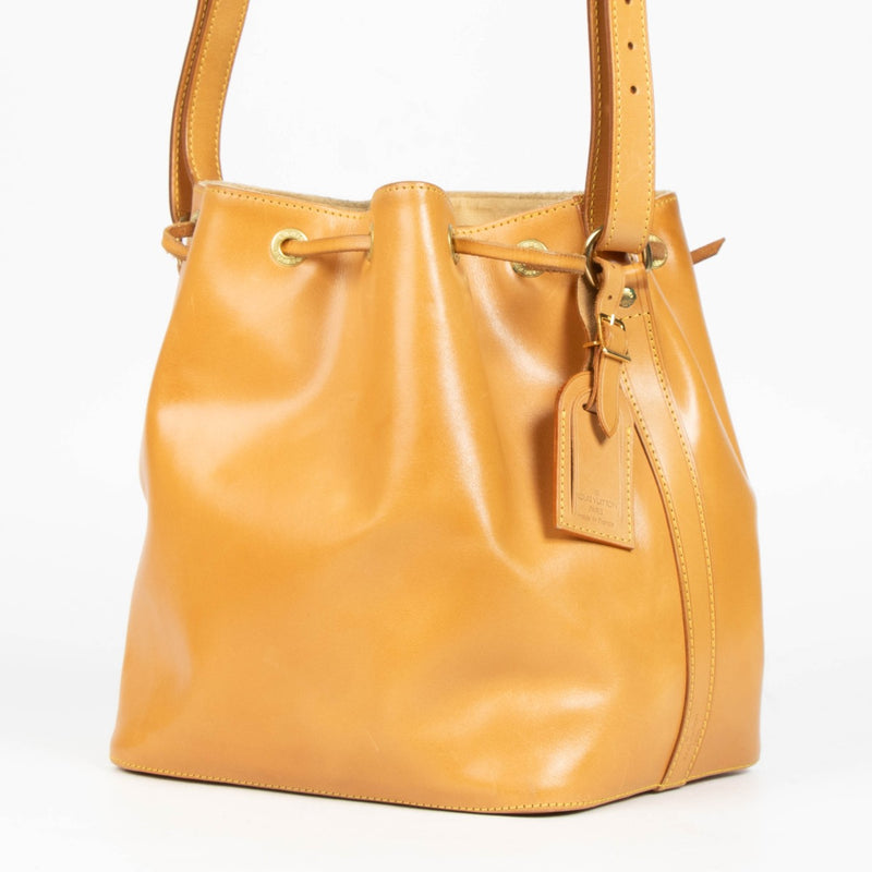 100% authentic second hand Louis Vuitton Nomade Leather Noé Bag with drawstring closure and adjustable shoulder strap.