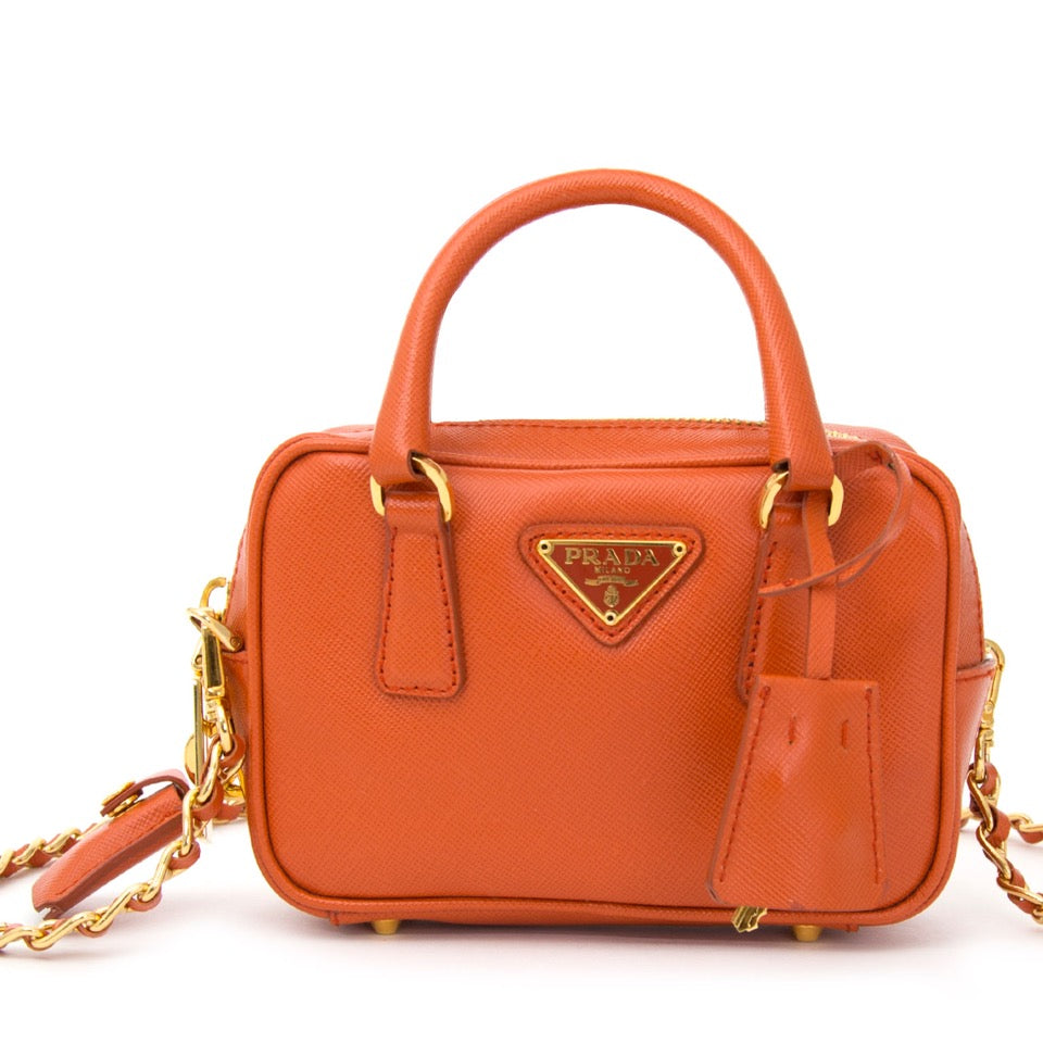 Authentieke Prada Oranje clutch tasje met gouden details voor de juiste prijs bij LabelLOV vintage webshop. Prada orange chain bag golden details. Veilig online winkelen. Luxe, vintage, mode. Antwerpen, België.