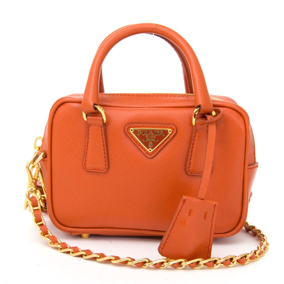 Authentieke Prada Oranje clutch tasje met gouden details voor de juiste prijs bij LabelLOV vintage webshop. Prada orange chain bag golden details. Veilig online winkelen. Luxe, vintage, mode. Antwerpen, België.
